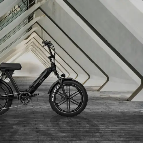 Vélo cargo électrique noir Yükargo garé sous un pont architectural triangulaire
